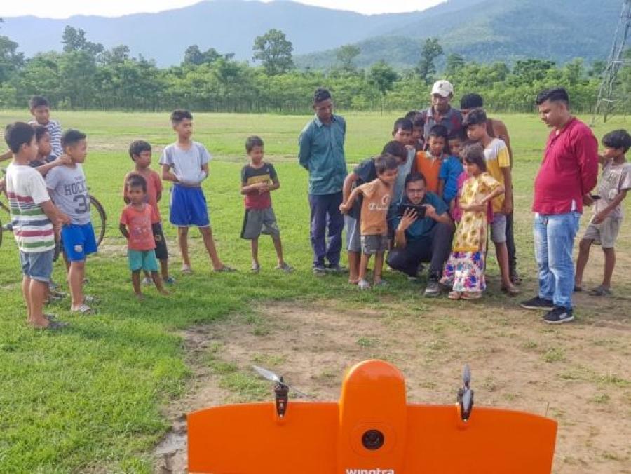 Local kids waiting for the drone to be flown as Nepal FL pilot plans the mission 570x428