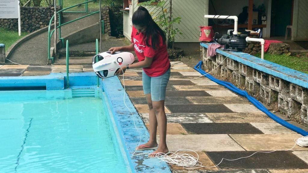 South Pacific Flying Labs' Amrita holding a PowerRay underwater drone.
